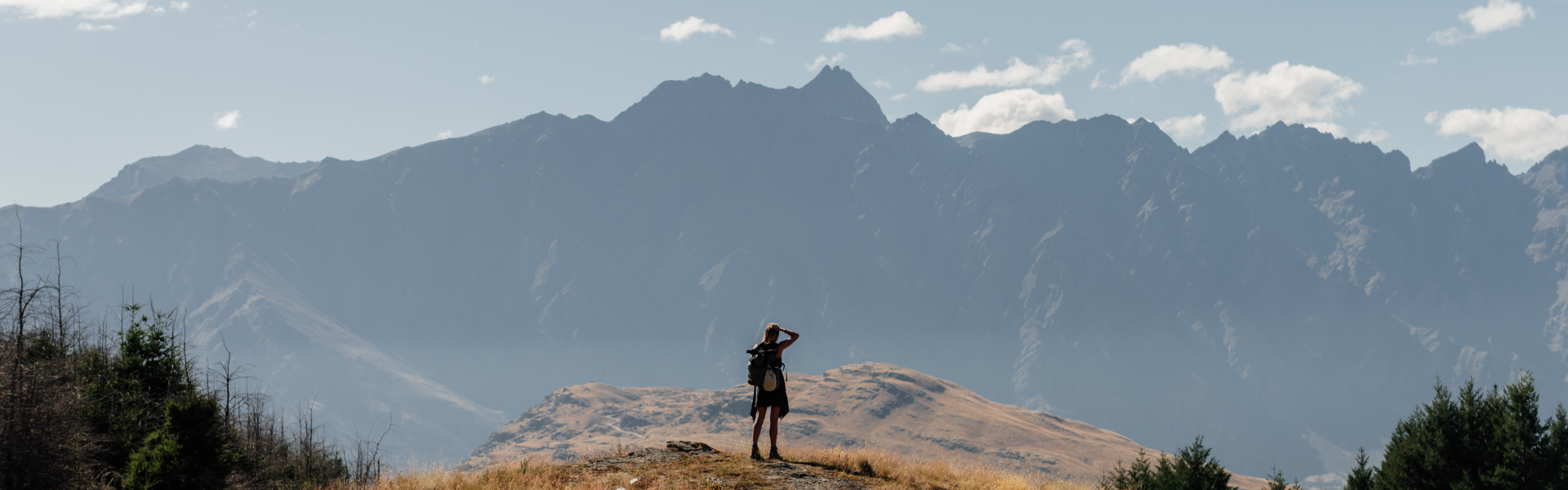 Lone hiker looking out over the Remarkables range above Queenstown