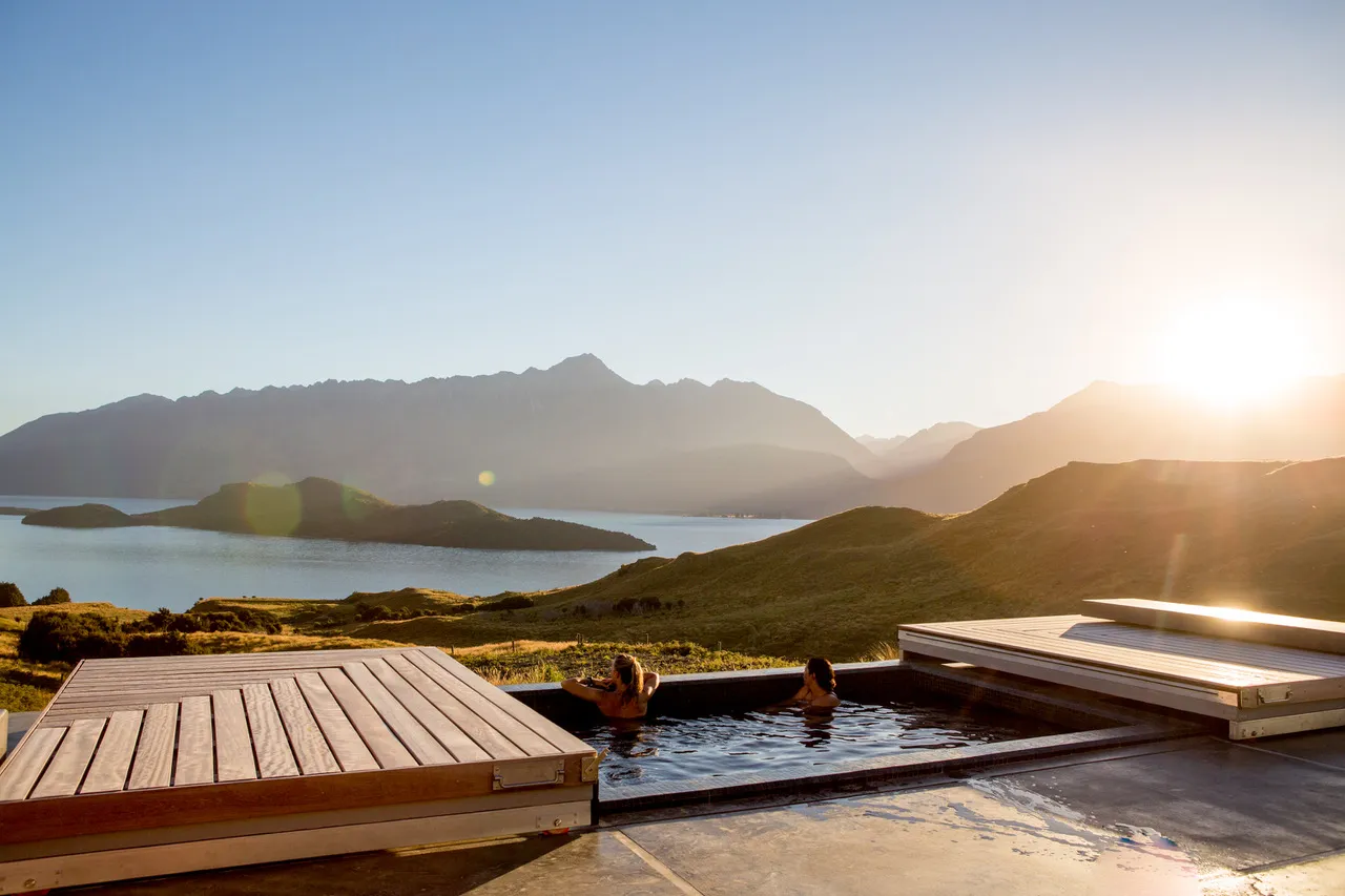 Infinity hot pools at Aro Hā retreat overlooking Lake Wakatipu at sunset